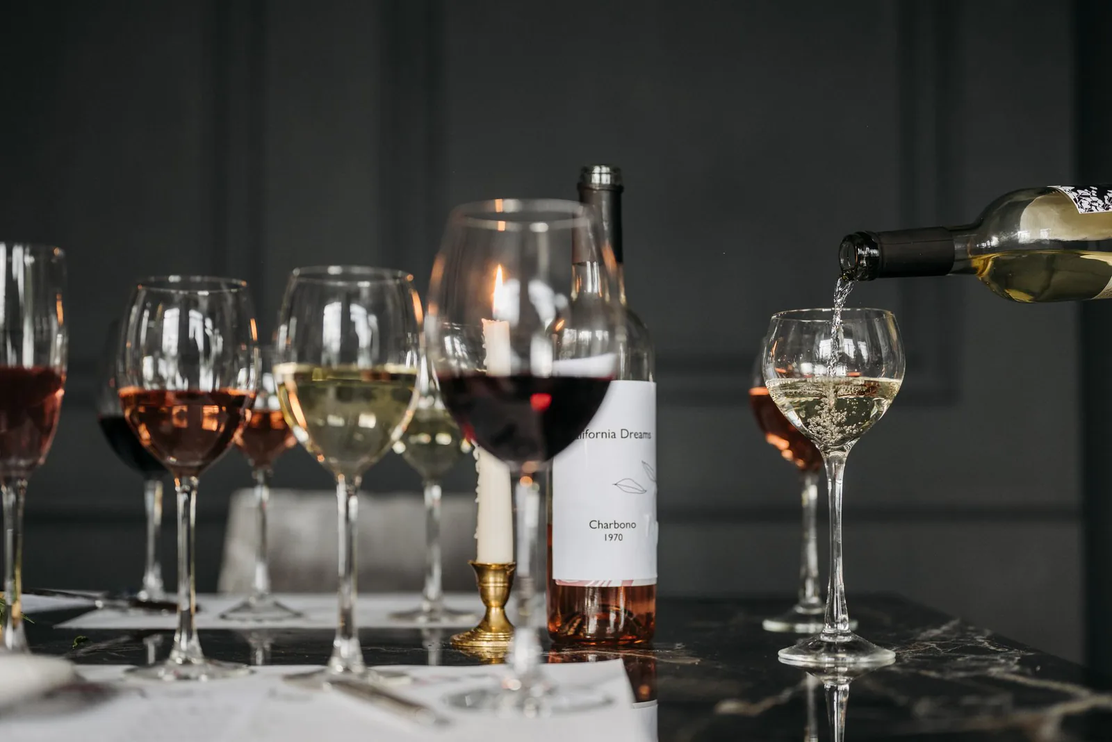 A row of tasting glasses arranged on a dimly lit table